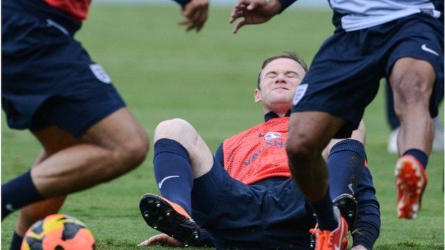 England"s national football team player Wayne Rooney (C) falls during a training sesssion in Rio de Janeiro, Brazil, on May 31, 2013