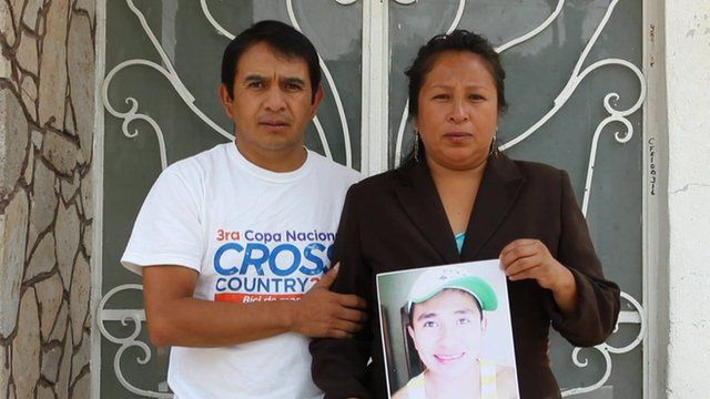 Mexican couple hold photo of their missing son