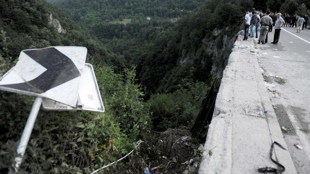 People look at the scene of a bus accident near Grlo