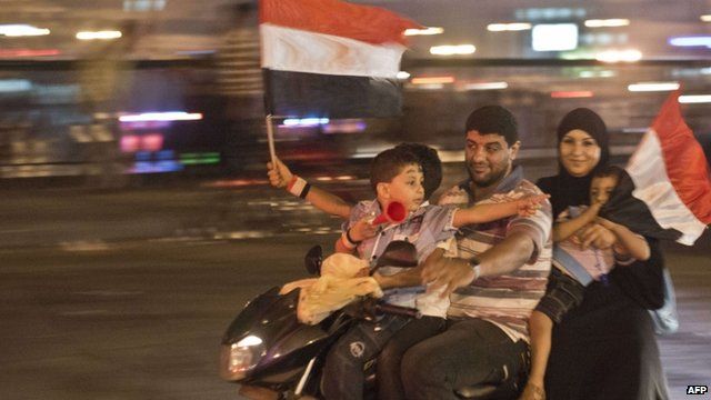 An Egyptian family on motorcycle celebrates in Cairo