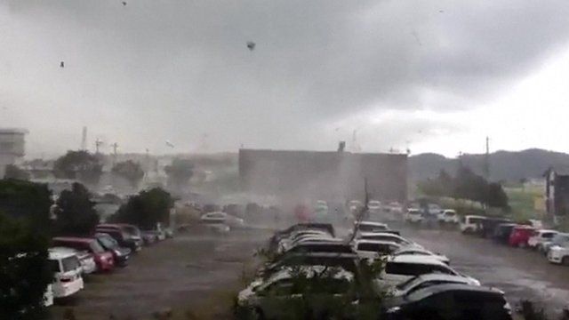 A tornado sweeps across a car park in Japan