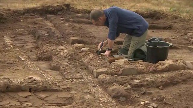 A volunteer works on excavating the training trench