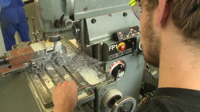 A young man using an industrial drill