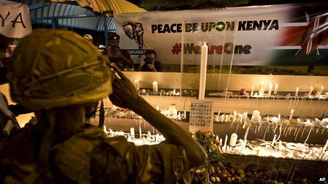Soldier salutes in front of tributes