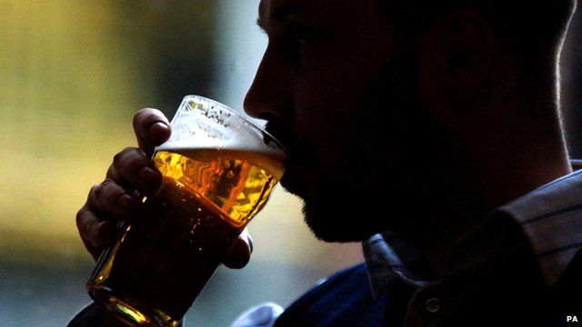 Anonymous man drinking pint of beer