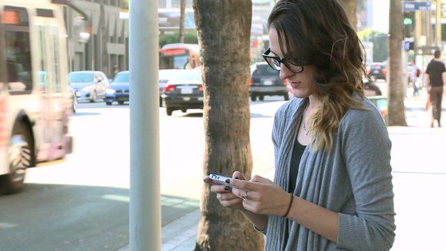 Woman uses phone in street