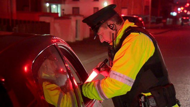 A police officer checking vehicles in Belfast