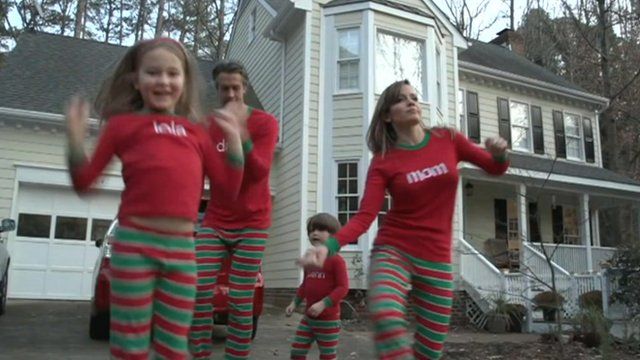 Family jumping around in Christmas pyjamas