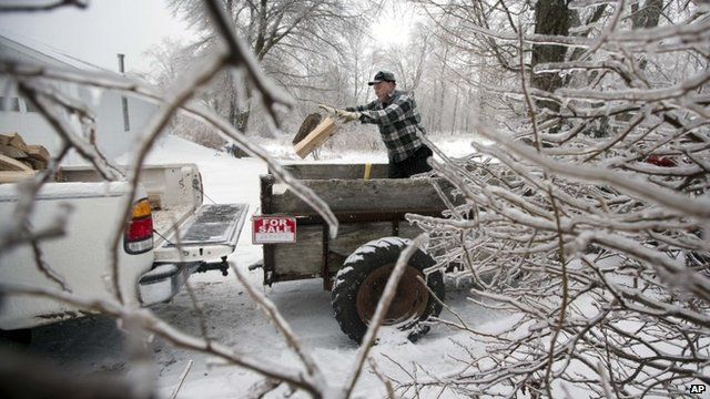 Ice from Monday's storm still clings to branches as Ken Finnegan loads his truck with firewood Thursday, Dec. 26, 2013, in Litchfield, Maine