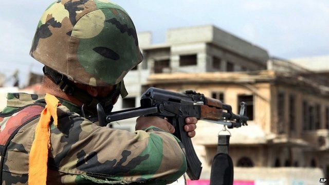 A Syrian army soldier takes his position, at a street in Sabina suburb