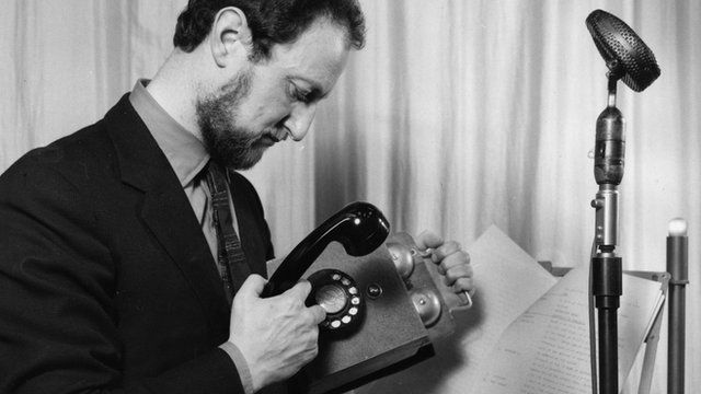 An old black and white photo showing a BBC studio manager recording the sound of an old phone