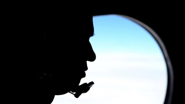 Silhouette of a man next to a window on a search aircraft
