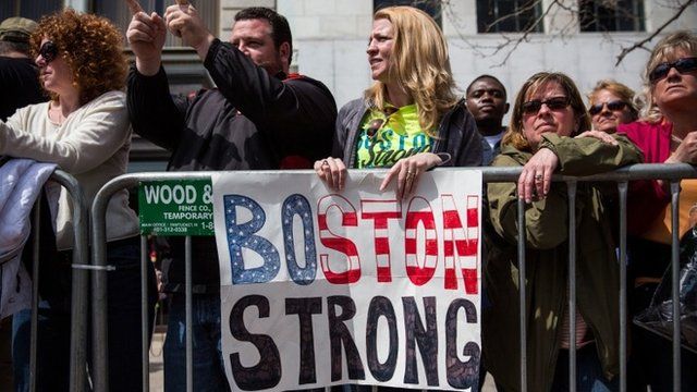 Fans with a "Boston Strong" poster cheer on runners as they finish the Boston Marathon on April 21, 2014 in Boston, Massachusetts