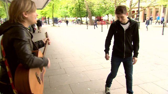 Luke Cameron gives busker money