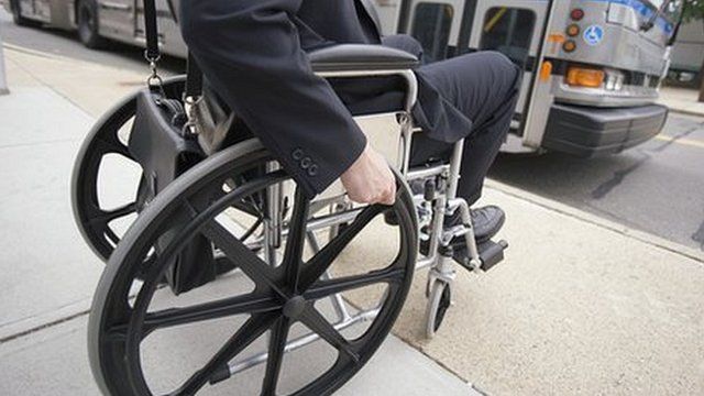 Man in wheelchair waiting for a bus