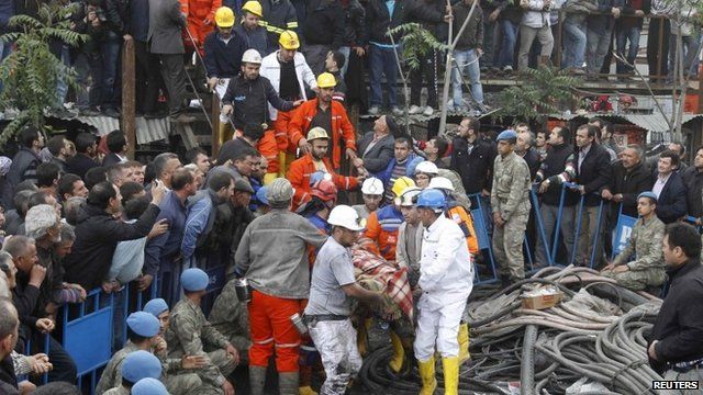 Rescuers carry a miner who sustained injuries after a mine explosion
