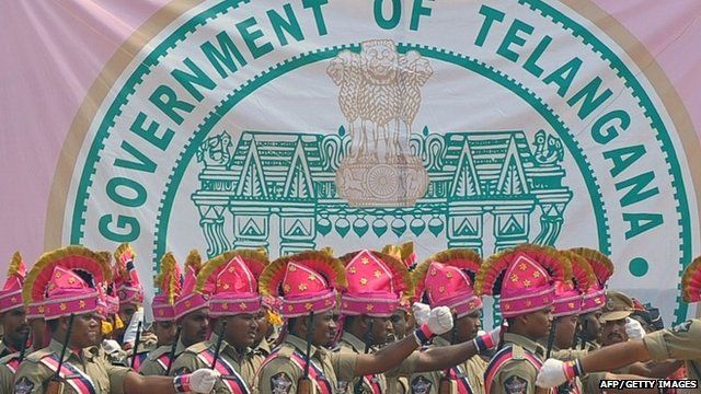 Newly-formed Telangana state policemen march past the new state's coat-of-arms