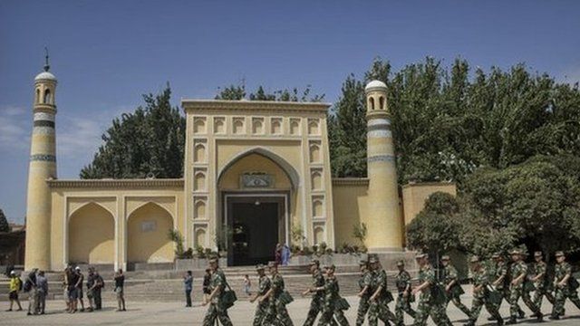 Chinese soldiers march in front of the Id Kah Mosque,