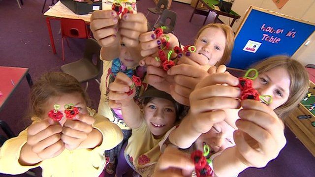 Children hold loom band poppies