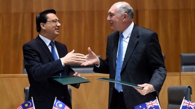 Australian Deputy Prime Minister Warren Truss (R) and Malaysian Transport Minister, Liow Tiong Lai shake hands