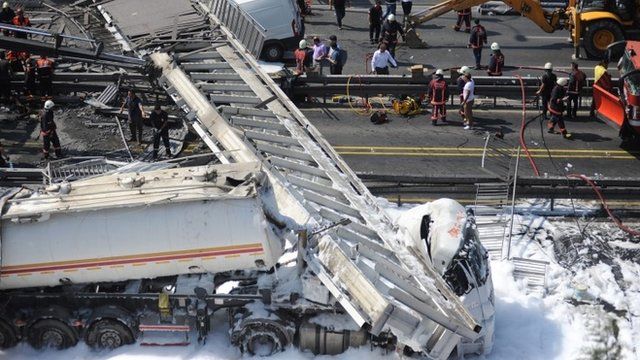 Rescue workers try to clear the area after a pedestrian bridge collapsed after it was hit by a fuel tanker on a main highway in Istanbul, Turkey 03 September 2014