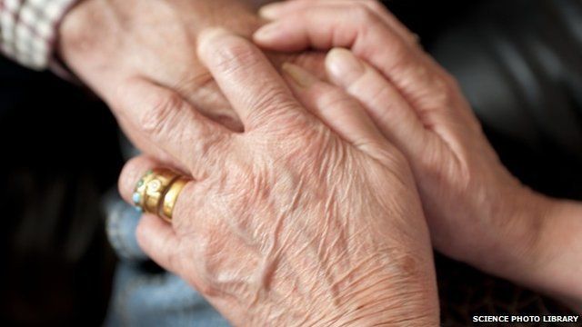 Carer holding an elderly patient's hand