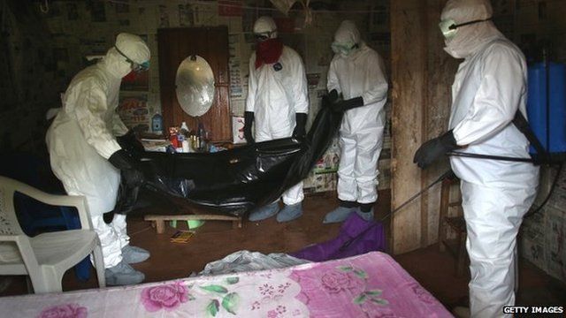 People in an Ebola affected area wearing protective clothing.