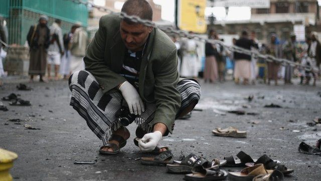 A Yemeni security official inspects the site of a suicide bombing in Sanaa, Yemen