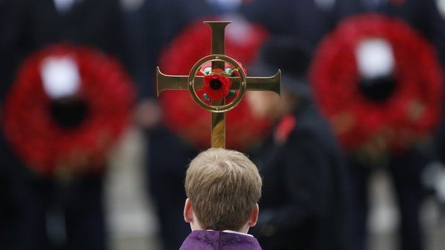 Boy holds cross at Cenotaph