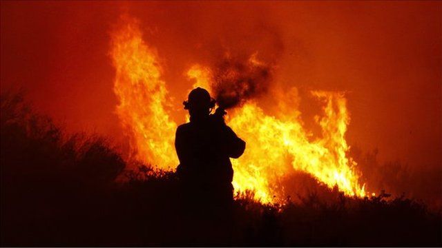 A fire-fighter tries to stop a blaze in Noordhoek Manor old age home, Cape Town, South Africa, 02 March 2015
