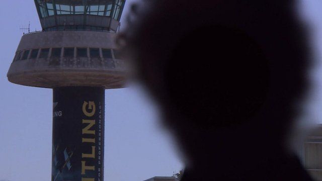 Blurred face of pilot (to avoid identification) in front of an air traffic control tower
