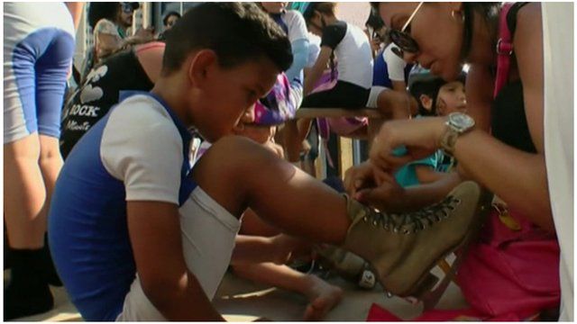 A child gets their laces tied