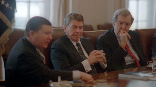 President Ronald Reagan seated at a meeting