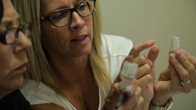 Women hold vials