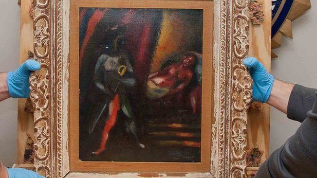 The FBI's Art Crime Team hold a framed work by Marc Chagall prior to its return to the owners' estate nearly 30 years after it was stolen.