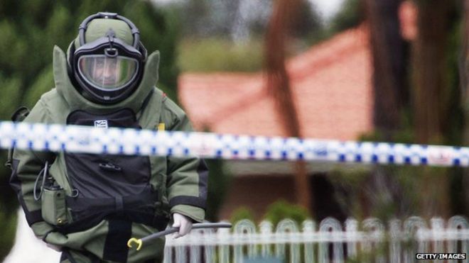 Офицер по обезвреживанию бомб идет по Уилсон-стрит в Зеленой долине 8 ноября 2005 года в Сиднее, Австралия.
