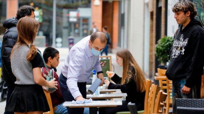A waiter cleaning a table