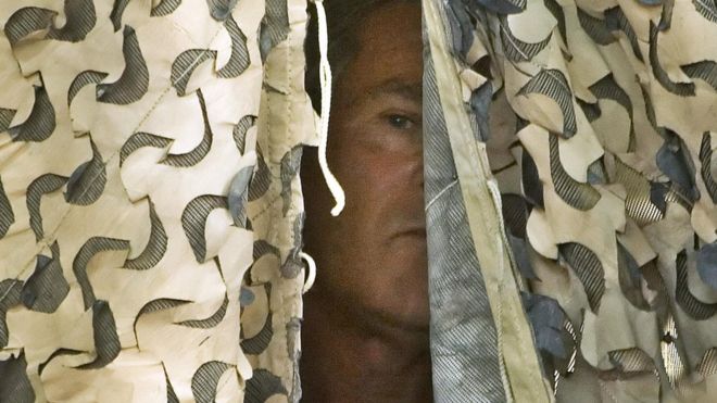 Президент США Джордж Буш ждет за камуфляжным занавесом перед тем, как 3 сентября 2007 года будет объявлено, что он будет говорить с войсками на авиабазе Аль-Асад в иракской провинции Аль-Анбар