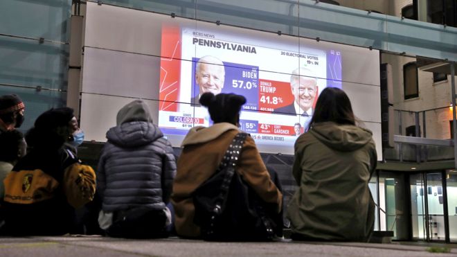 People assistindo a telões na Pensilvânia