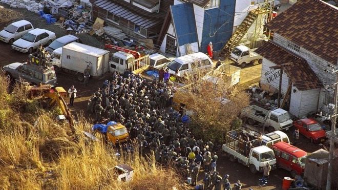 Полицейские совершают рейд на соединения японского культа Судного дня Аум Синрикё 22 марта 1995 года.