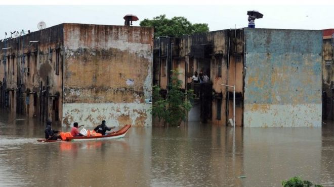 Спасатели несут еду в лодке для раздачи людям, захваченным в затопленном жилом районе в Ченнаи, в южном индийском штате Тамилнад, среда, 2 декабря 2015 г.