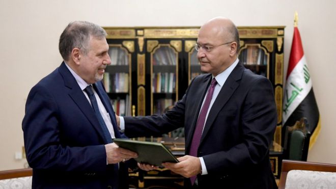 President Barham Salih (R) instructs new Prime Minister Mohammed Tawfiq Allawi