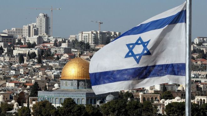 The Israeli flag flutters in front of the Dome of the Rock mosque and the city of Jerusalem, on December 1, 2017.