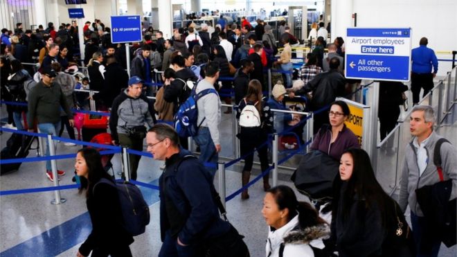 Путешественники прибывают для проверки TSA, когда они пробираются через международный аэропорт Ньюарк-Либерти в Ньюарке, Нью-Джерси