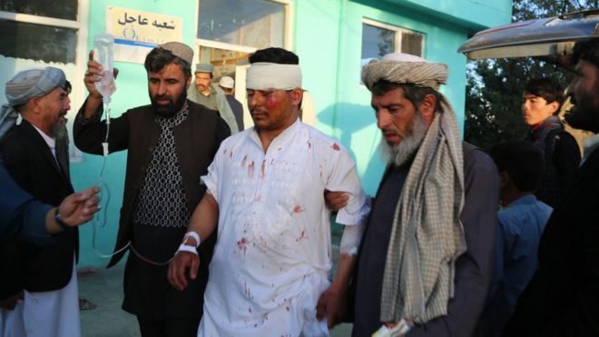 Мужчины помогают раненому родственнику в городе Газни