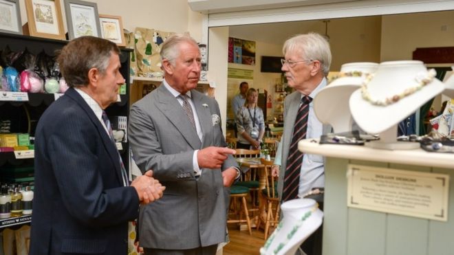 Принц Чарльз осматривает сувенирный магазин перед тем, как открыть витраж в Myddfai Community Hall около Llandovery, Carmarthenshire