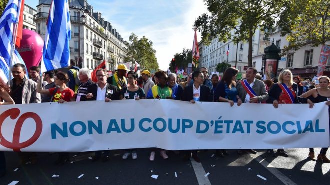 Протестующие держат плакат с надписью «Нет социальному перевороту». во время демонстрации против французских правительственных трудовых реформ в Париже, 23 сентября 2017 года