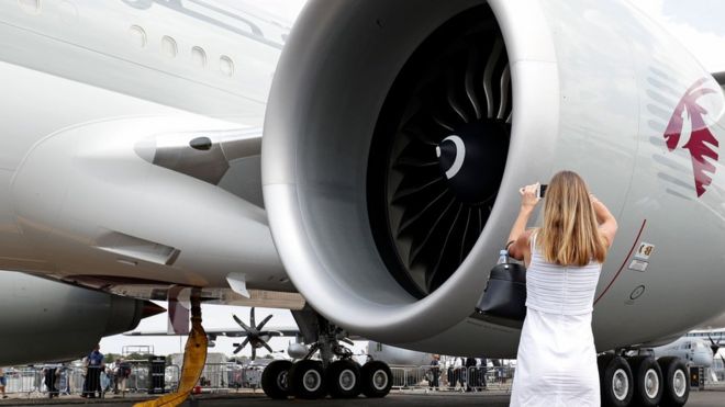 Женщина фотографирует двигатель GE внутри самолета Qatar Airways