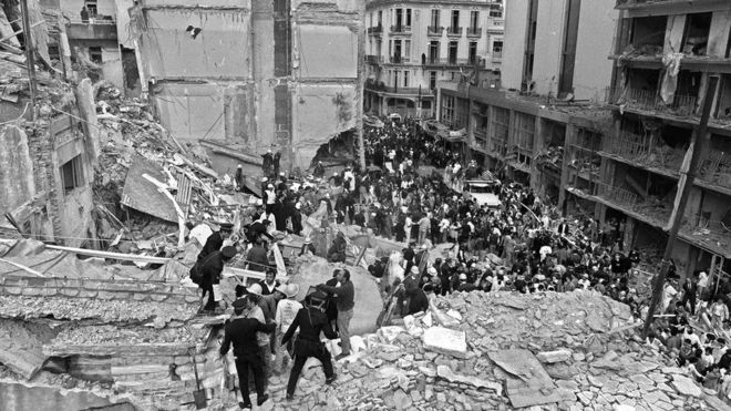 Пожарные, полицейские и спасатели обыскивают место взрыва бомбы в Аргентинской израильской взаимной ассоциации (AMIA) в Буэнос-Айресе, 18 июля 1994 года