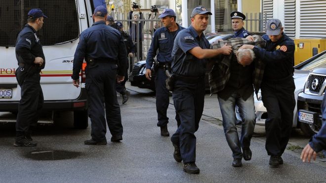 Черногорских полицейских сопровождает мужчина в специальный суд в Подгорице 16 октября 2016 года